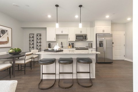 a large kitchen with a center island with three stools
